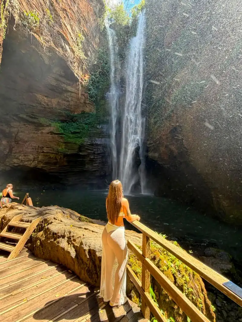 Viajante no deck de madeira olhando a Cachoeira Santa Bárbara entre paredões