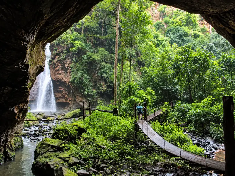 Entrada do cânion do Santuário da Pedra Caída, com ponte suspensa e cachoeira ao fundo